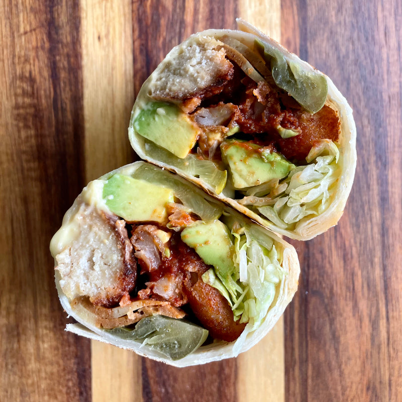 BBQ cheddar burrito cut in half, showing smoky Not Meat, avocado and lettuce